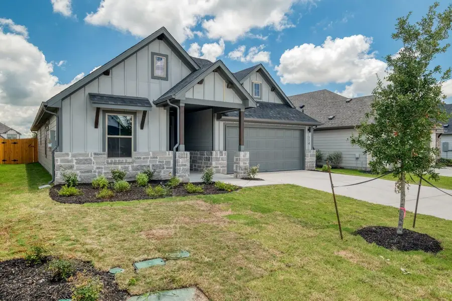 A newly constructed residence showcasing board and batten siding, stone accents, and an attached garage. A newly constructed residence showcasing board and batten siding, stone accents, and an attached garage.