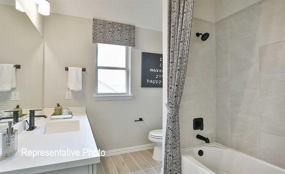 Full bathroom featuring vanity, toilet, tile floors, and shower / tub combo with curtain