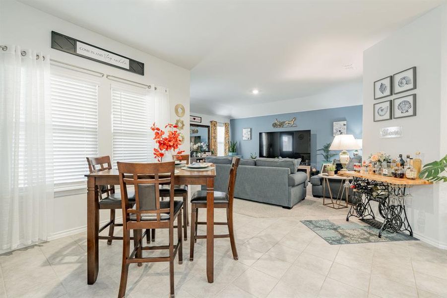 Dining area with light tile patterned floors and baseboards