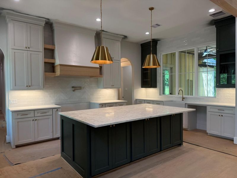 Kitchen featuring arched walkways, decorative backsplash, a kitchen island, and recessed lighting