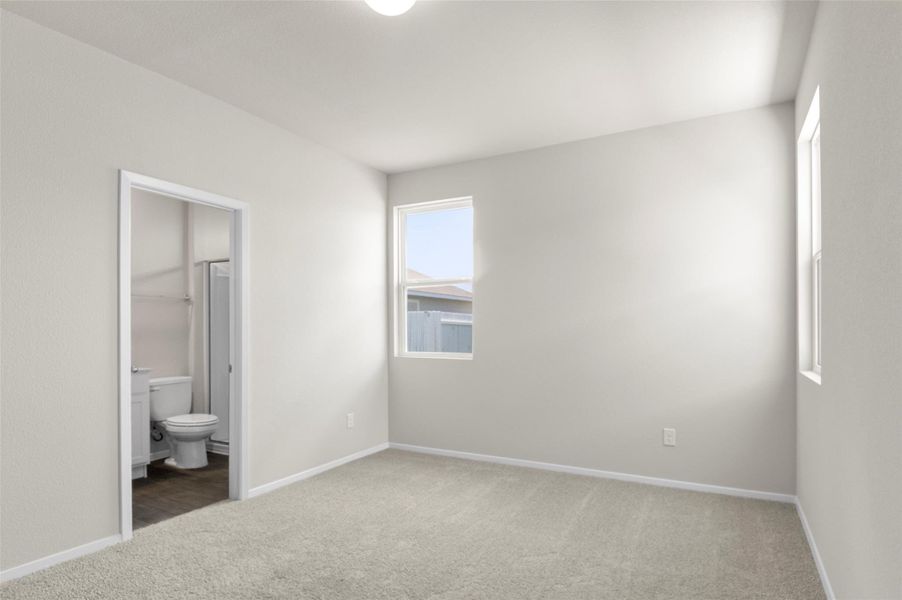 Unfurnished bedroom with light colored carpet and ensuite bathroom