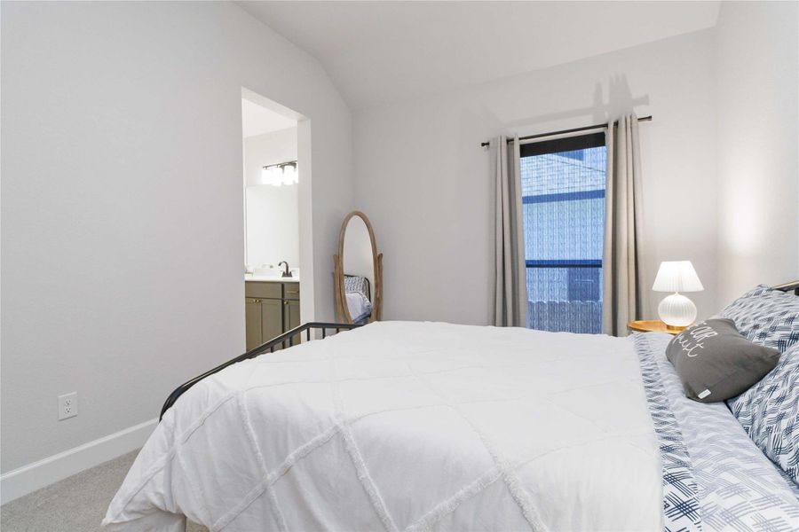 Carpeted bedroom with baseboards and ensuite bath Carpeted bedroom with baseboards and ensuite bath