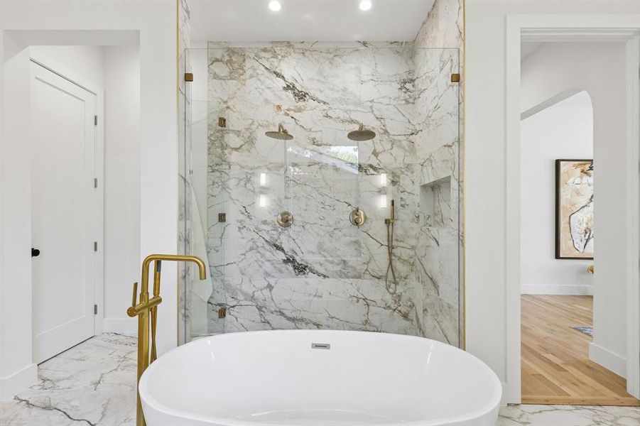 Bathroom featuring a marble finish shower, a freestanding tub, recessed lighting, and light marble finish floors