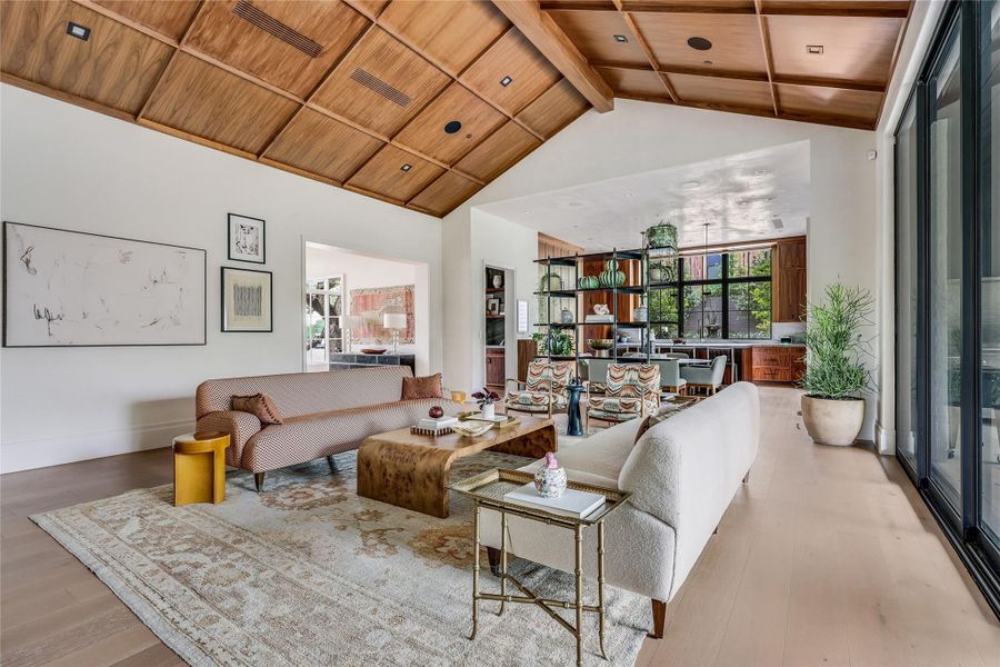 A striking living space boasts a magnificent vaulted wood-paneled ceiling and oak floors.