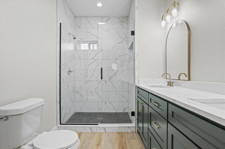 Bathroom with vanity, wood-type flooring, an enclosed shower, and toilet