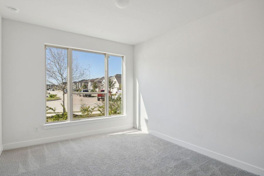 This comfortable secondary bedroom on the first floor features its own private bath, offering an inviting space ready for your personal touches.
