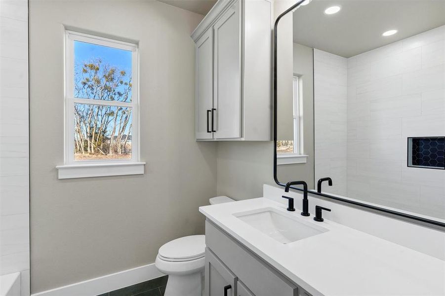 Bathroom featuring tile patterned flooring, vanity, and toilet