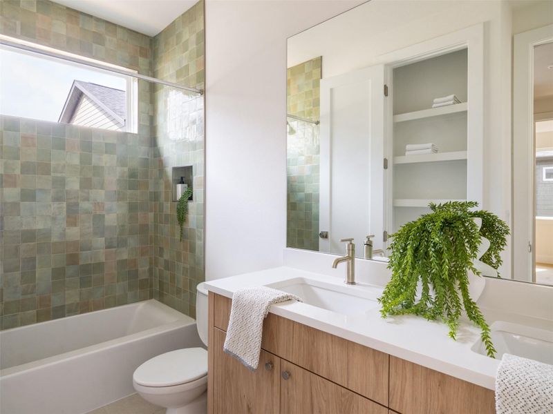 Bathroom featuring a full-size tub with an overhead window, green square tile surround, a built-in shower niche, and a vanity with a white countertop and wood-finish cabinetry
