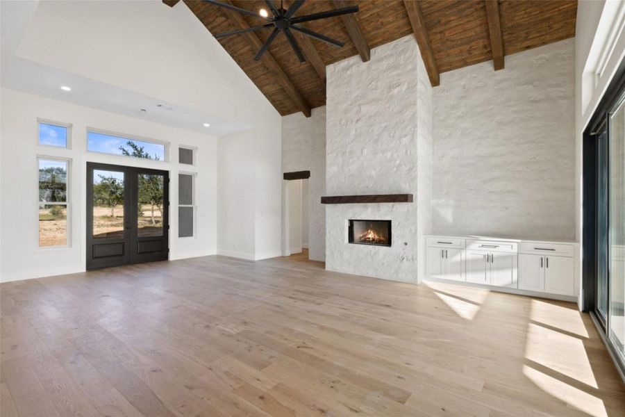 A spacious living area features a grand fireplace, vaulted wood-beamed ceilings, and natural hardwood flooring. A spacious living area features a grand fireplace, vaulted wood-beamed ceilings, and natural hardwood flooring.
