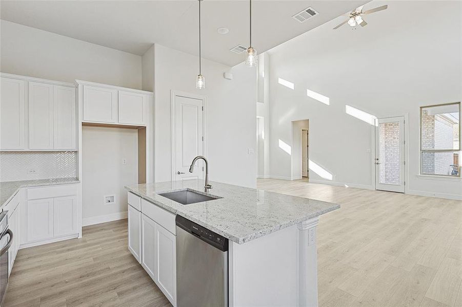 Kitchen featuring white cabinetry, sink, and stainless steel dishwasher