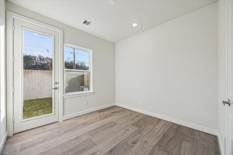 Large windows and a glass-paneled door flood this serene retreat with natural light while offering a seamless visual connection to the private outdoor space.