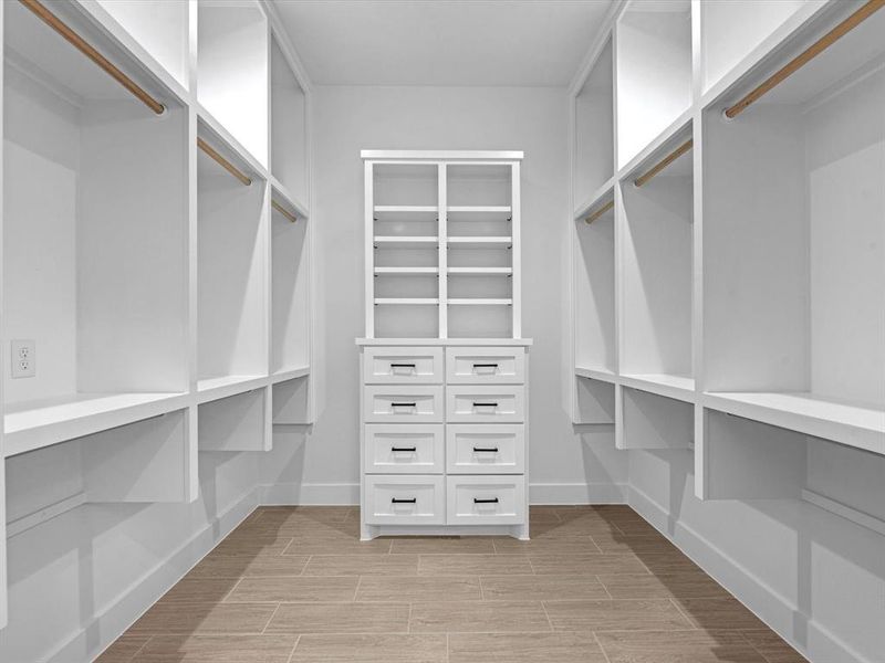 There is plenty of space in this custom primary walk in closet featuring drawers, shelving, and more space to add a vanity, safe, or more closet space.