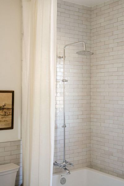 Bathroom featuring shower / bath combination with curtain and tile walls