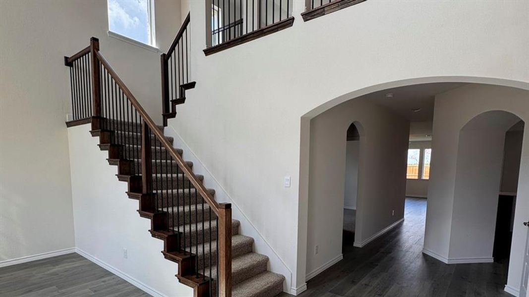 Stairway with wood finished floors and a high ceiling Stairway with wood finished floors and a high ceiling