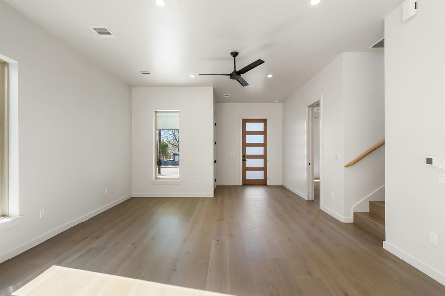 Entrance foyer featuring baseboards, visible vents, stairway, light wood-style floors, and recessed lighting