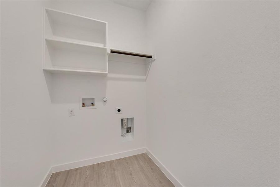 Washroom with washer hookup, light wood-type flooring, hookup for a gas dryer, and electric dryer hookup