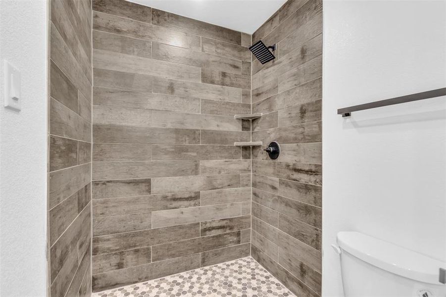 Bathroom with tiled shower and toilet