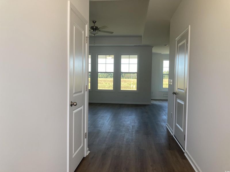 Hallway featuring dark wood-type flooring and baseboards