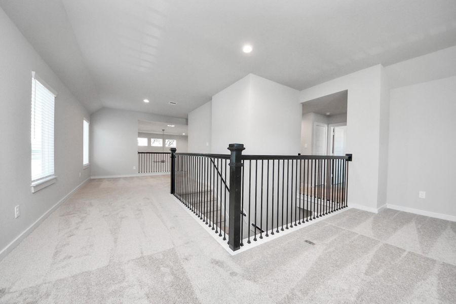 Ascend to relaxation in this fantastic game room! Ideal for both casual gatherings and adult gaming, it boasts plush carpet, lofty ceilings, custom paint, and ample windows for abundant natural light. Sample photo of completed home with similar floor plan. Actual colors and selections may vary.