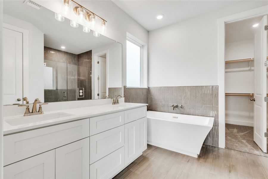 A well-appointed bathroom features a double vanity, separate tub, and walk-in shower.