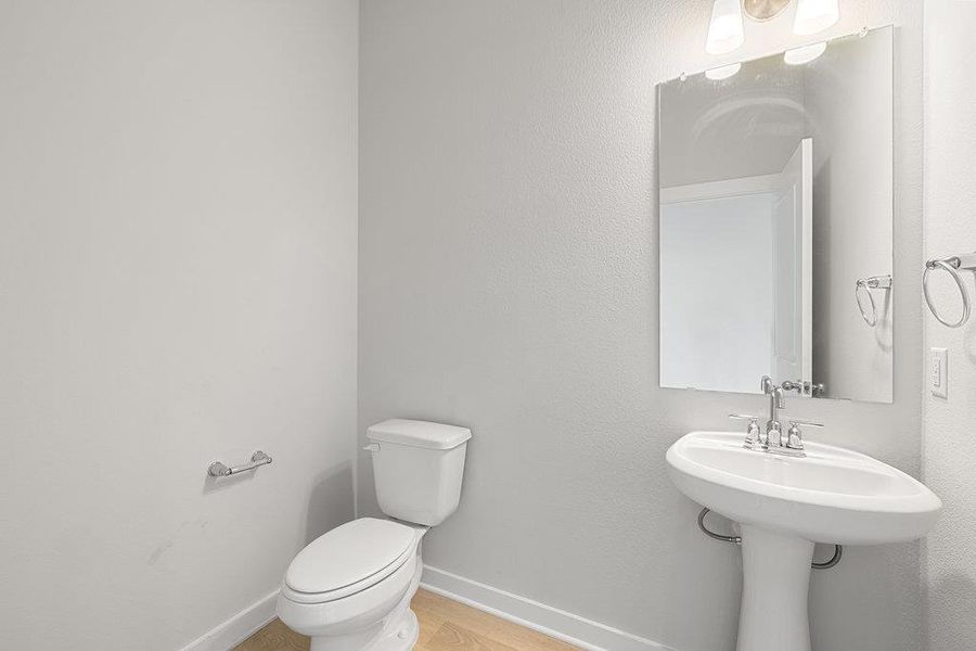 Bathroom featuring baseboards and light wood-type flooring