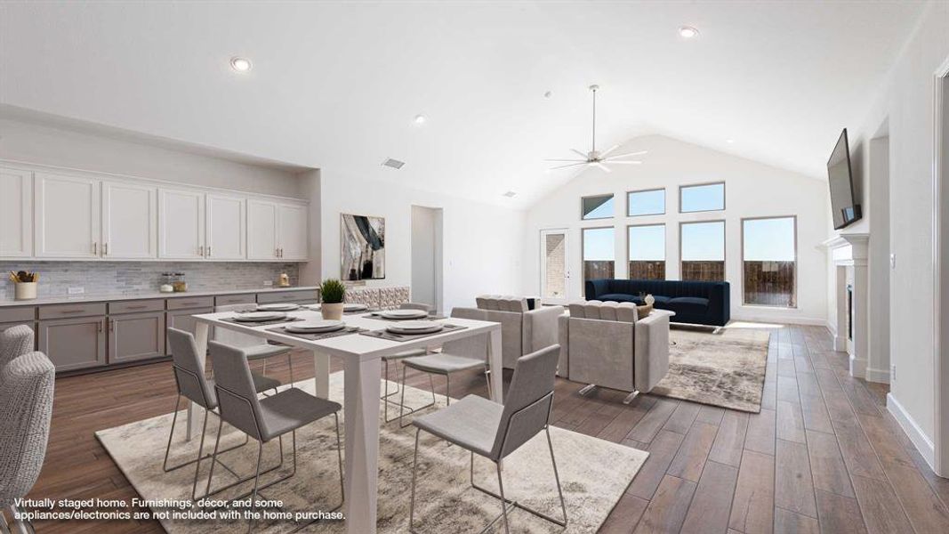 Dining area with high vaulted ceiling, ceiling fan, and dark wood-type flooring