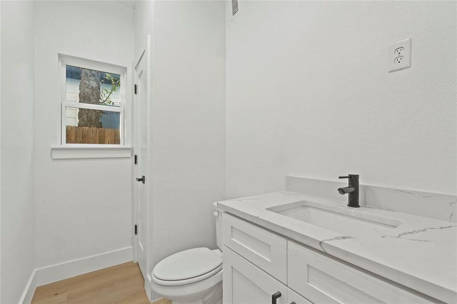 Half bath with vanity and light wood-type flooring Half bath with vanity and light wood-type flooring