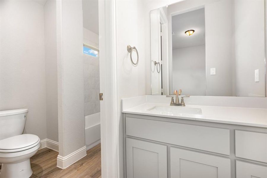 Full bath featuring vanity, light wood-style floors, and washtub / shower combination
