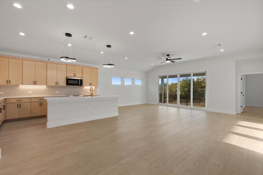Kitchen featuring light brown cabinets, recessed lighting, open floor plan, pendant lighting, and a center island with sink Kitchen featuring light brown cabinets, recessed lighting, open floor plan, pendant lighting, and a center island with sink
