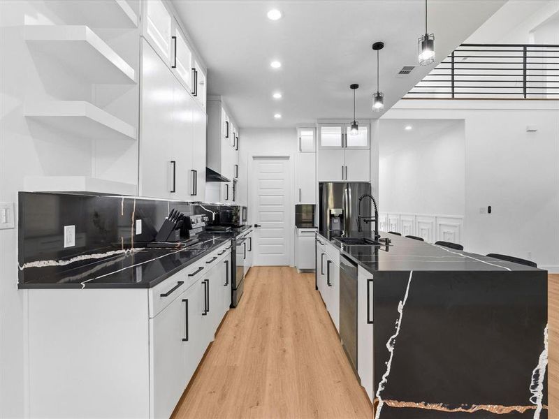 Contemporary kitchen featuring light wood-finish flooring and a spacious island with seating
