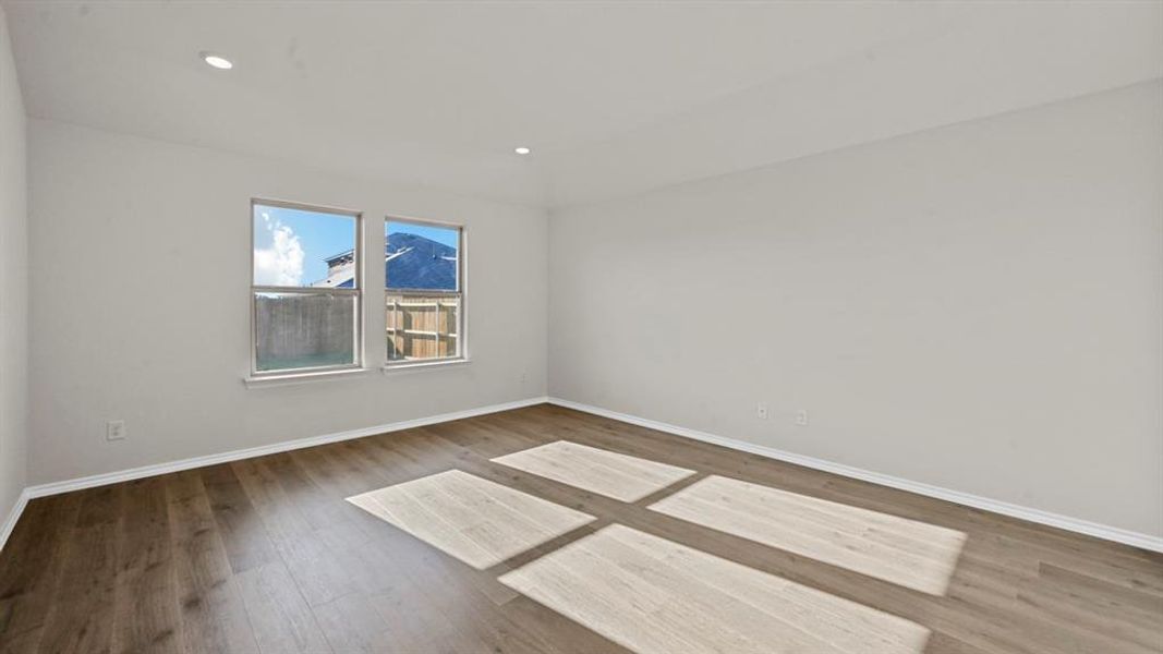 Empty room with dark wood-style flooring and recessed lighting
