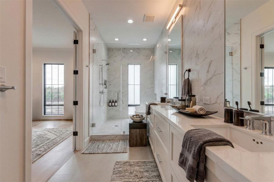 View of the primary bath highlighting the extended double vanity, frameless glass-enclosed shower, and freestanding tub positioned beneath a tall window. Large tiles and sleek fixtures create a serene spa ambiance within the private third-floor retreat. This photo has been virtually staged for visual reference.