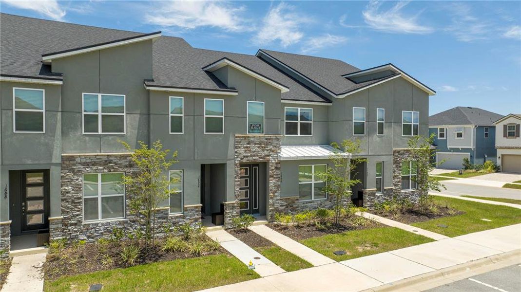 Front exterior of a new home in Solara Resort, Kissimmee, FL, highlighting curb appeal (Image 22).