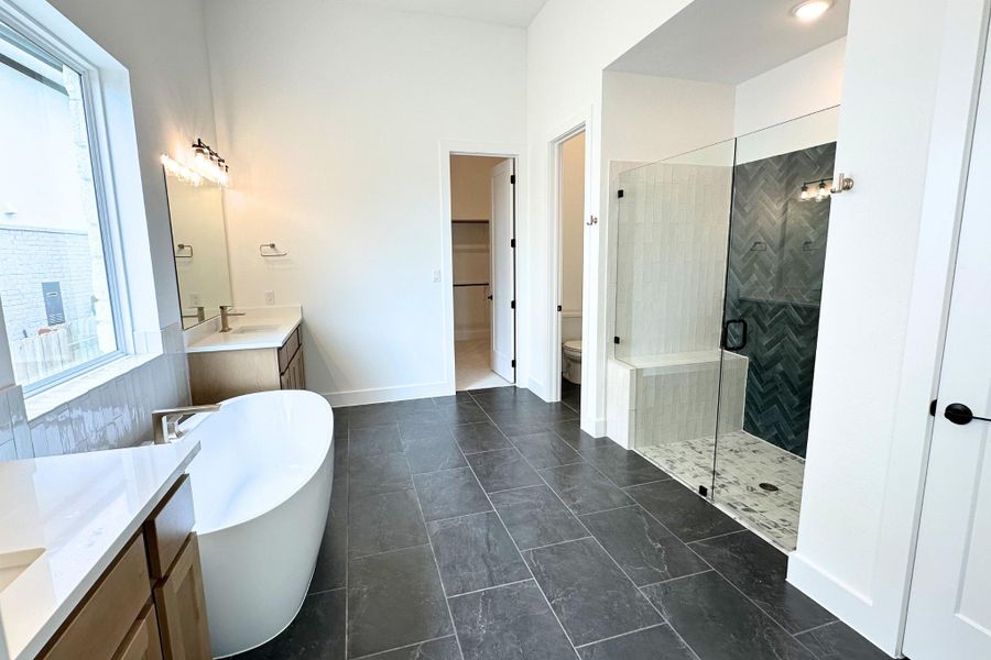 Luxurious primary bath features a freestanding soaking tub, dual vanities, and an expansive walk-in shower.