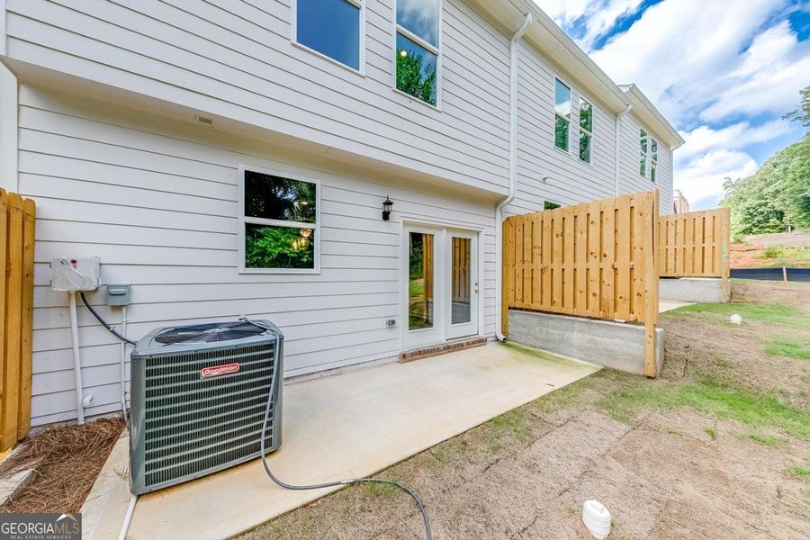 Exterior details and patio area of a home in Chimney Oaks Townhomes, Homer (Image 15).