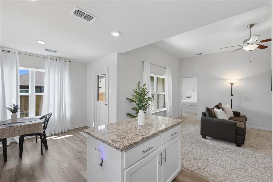 Kitchen featuring white cabinetry, light stone counters, recessed lighting, a ceiling fan, and light wood-style flooring