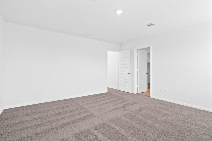 Another perspective of the primary bedroom to the walk-in closet and entrance to primary bathroom.