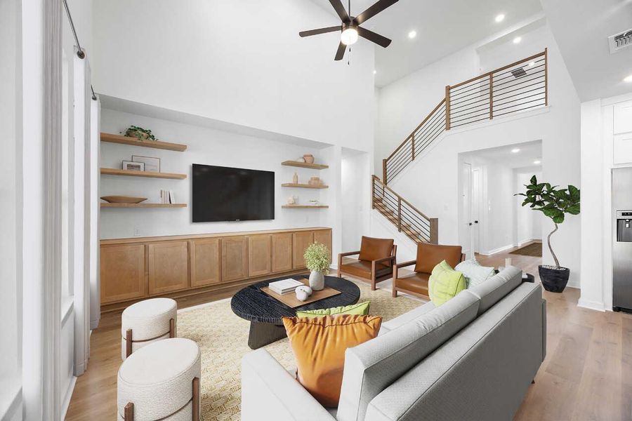 Living area with a high ceiling, light wood-style floors, recessed lighting, ceiling fan, and built in features Living area with a high ceiling, light wood-style floors, recessed lighting, ceiling fan, and built in features