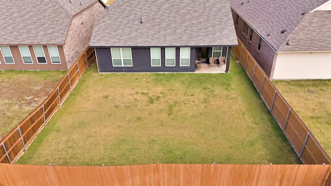 Back of property with a lawn and a patio area