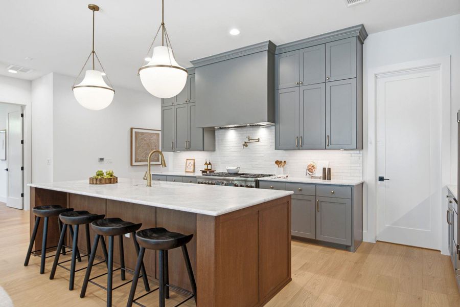 Premium stone countertops and detailed custom cabinetry elevate this contemporary culinary space.