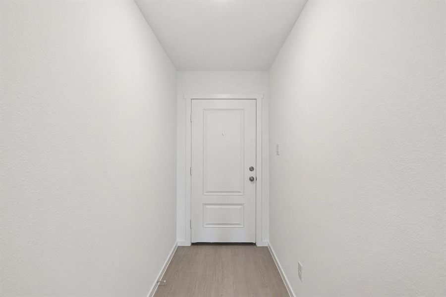 Entryway with light wood finished floors and baseboards
