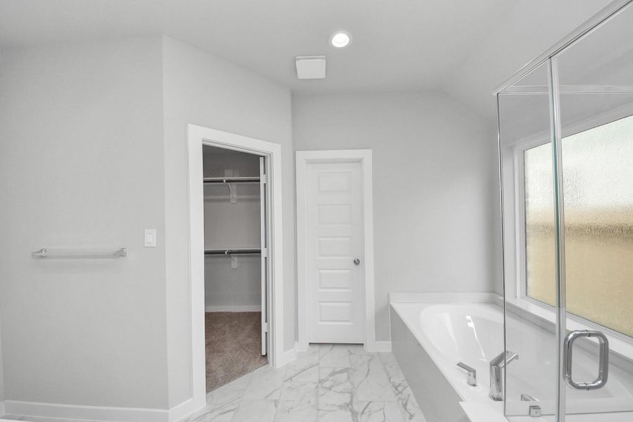 Indulge in the serenity of your primary bathroom, a true retreat designed for relaxation. The spacious walk-in shower, encased in elegant tile, invites you to unwind, while the separate garden tub, featuring unique, custom details, offers a perfect place for soaking away the day's stresses. Indulge in the serenity of your primary bathroom, a true retreat designed for relaxation. The spacious walk-in shower, encased in elegant tile, invites you to unwind, while the separate garden tub, featuring unique, custom details, offers a perfect place for soaking away the day's stresses.