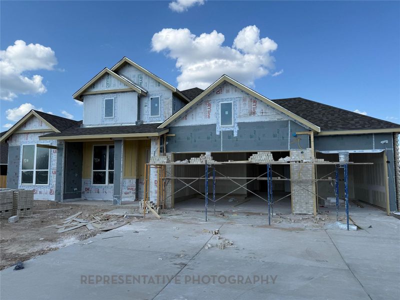 Property under construction featuring roof with shingles and covered porch