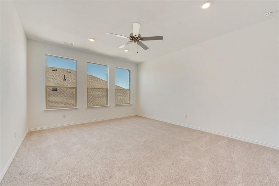 Carpeted spare room with ceiling fan