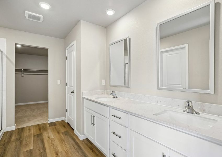 The master bathroom has a dual sink vanity and step in shower.