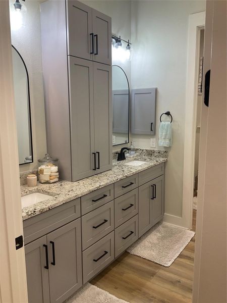 Guest hallway bathroom, has dual vanities and custom cabinetry, nice tub/shower with custom tile to ceiling