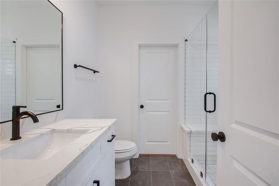 Walk-in glass enclosed shower. Photos of similar completed home by same builder. Selections may differ.