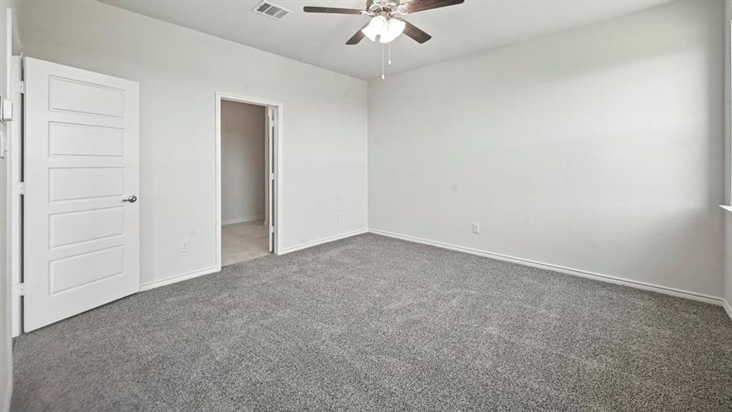 Spacious room featuring gray carpet, a ceiling fan with integrated lighting, and neutral wall paint