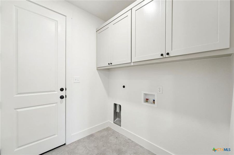 Functional laundry room offers upper cabinetry and ample space for appliances. Functional laundry room offers upper cabinetry and ample space for appliances.