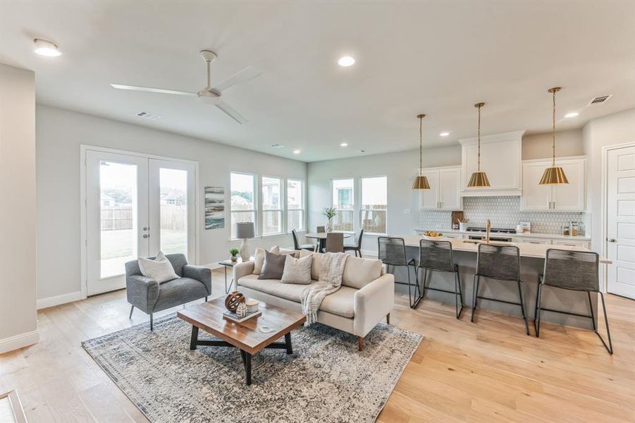 Living room featuring ceiling fan, sink, light wood-type flooring, and french doors